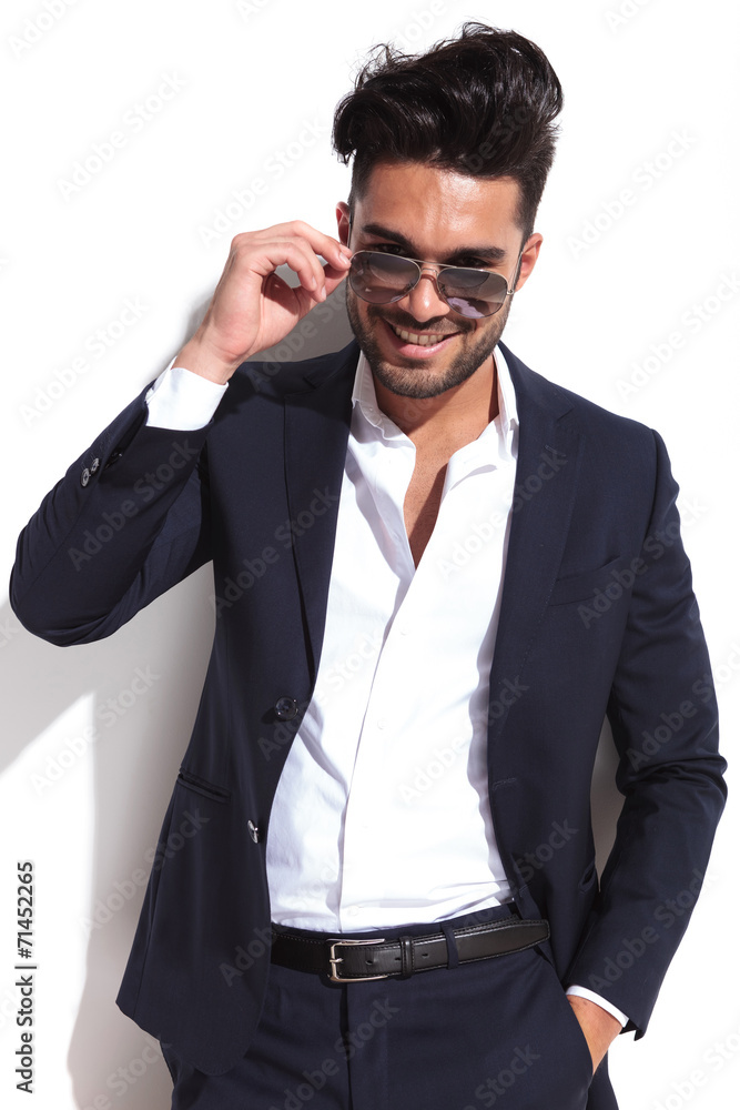 Smiling business man putting on his sunglasses Smiling business man putting on his sunglasses