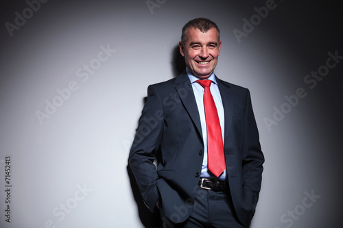 business man smiling while holding his hands in pocket