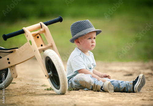 Little boy with tricycle in nature photo