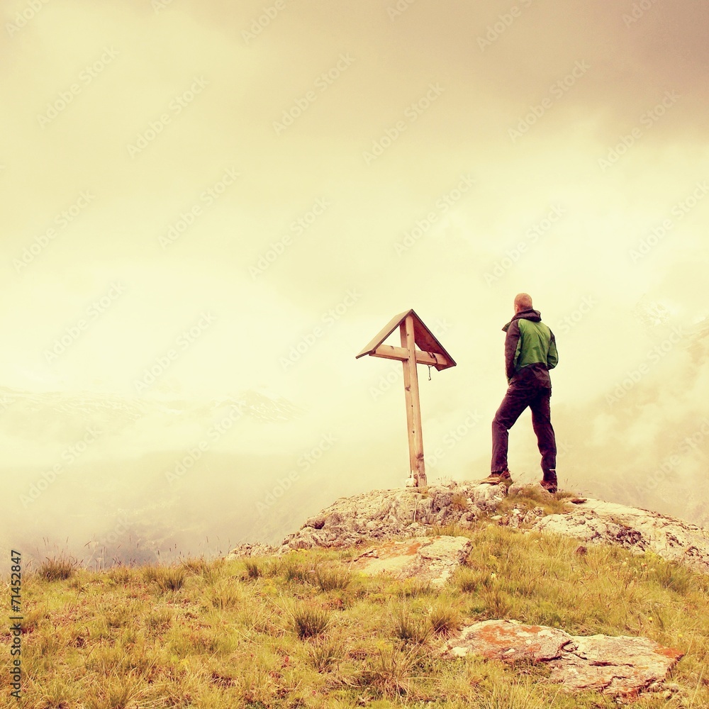 Obraz premium Tourist stand on rocky view point and watching into misty Alpine
