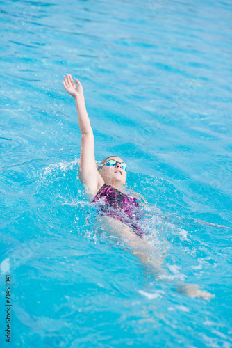 Woman in goggles swimming back crawl style