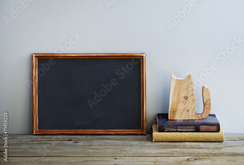 chalkboard frame on the grey wall with books and cat