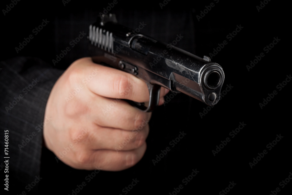 Closeup photo ob black pistol in male hand Closeup photo ob black pistol in male hand