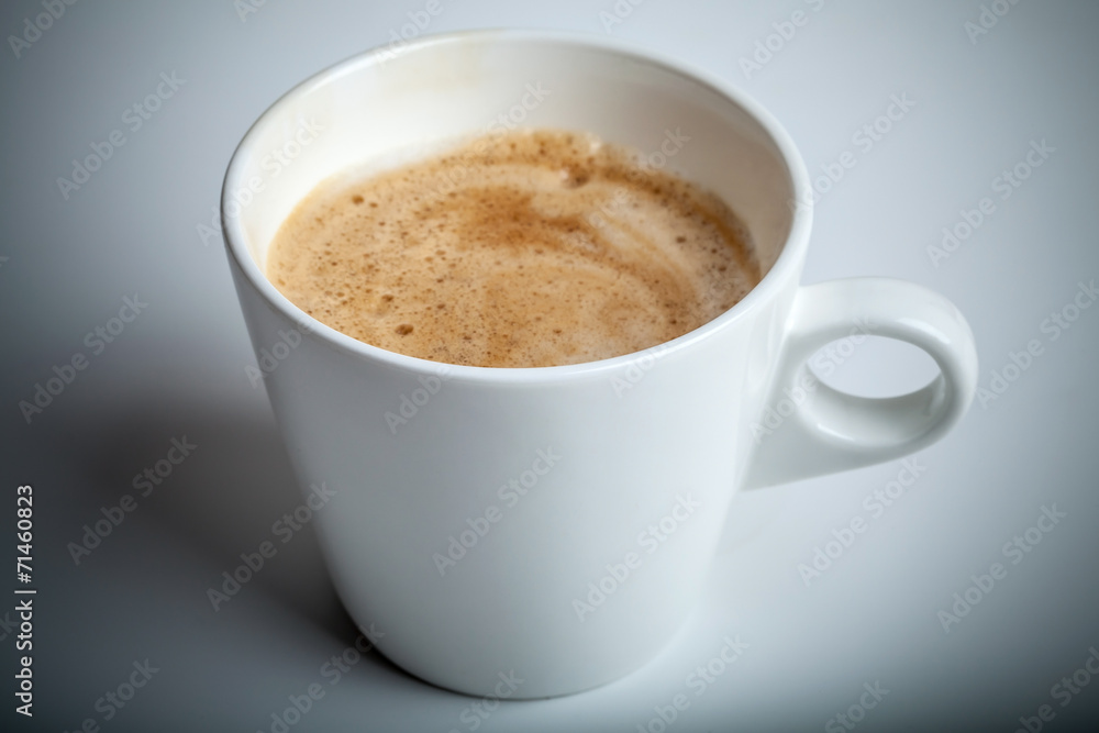 Cappuccino coffee in white ceramic cup on the table Cappuccino coffee in white ceramic cup on the table