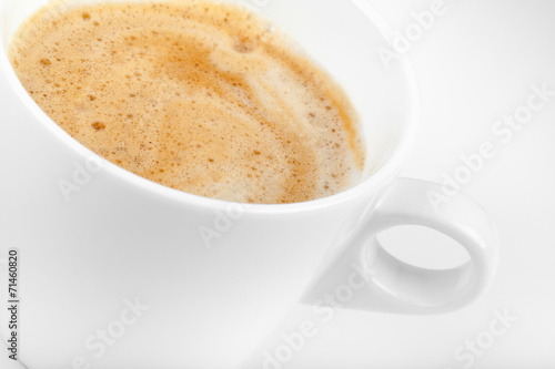 Cappuccino coffee in white ceramic cup, macro photo with selecti