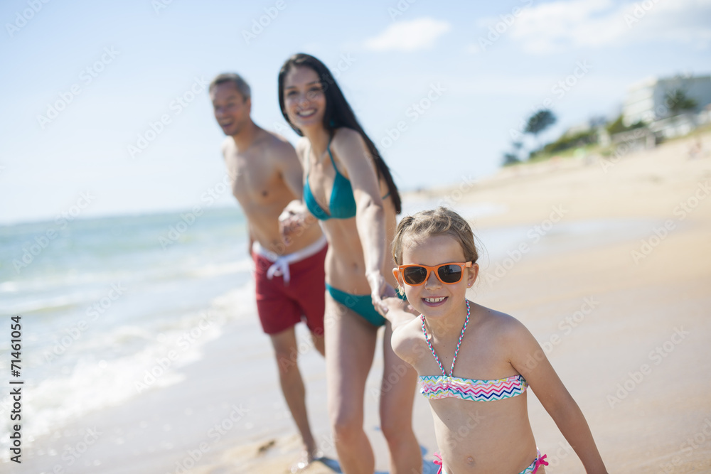 nice family in swimsuit walking on the beach Stock Photo