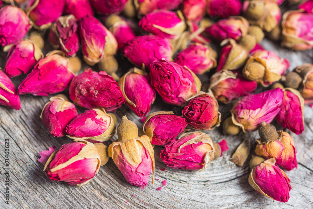 Dried tea rose buds on old wooden background - obrazy, fototapety, plakaty 
