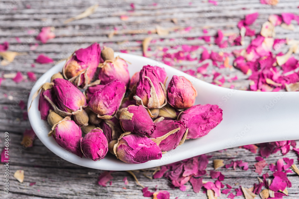rose petals and dried flowers in spoon on old wooden table rose petals and dried flowers in spoon on old wooden table
