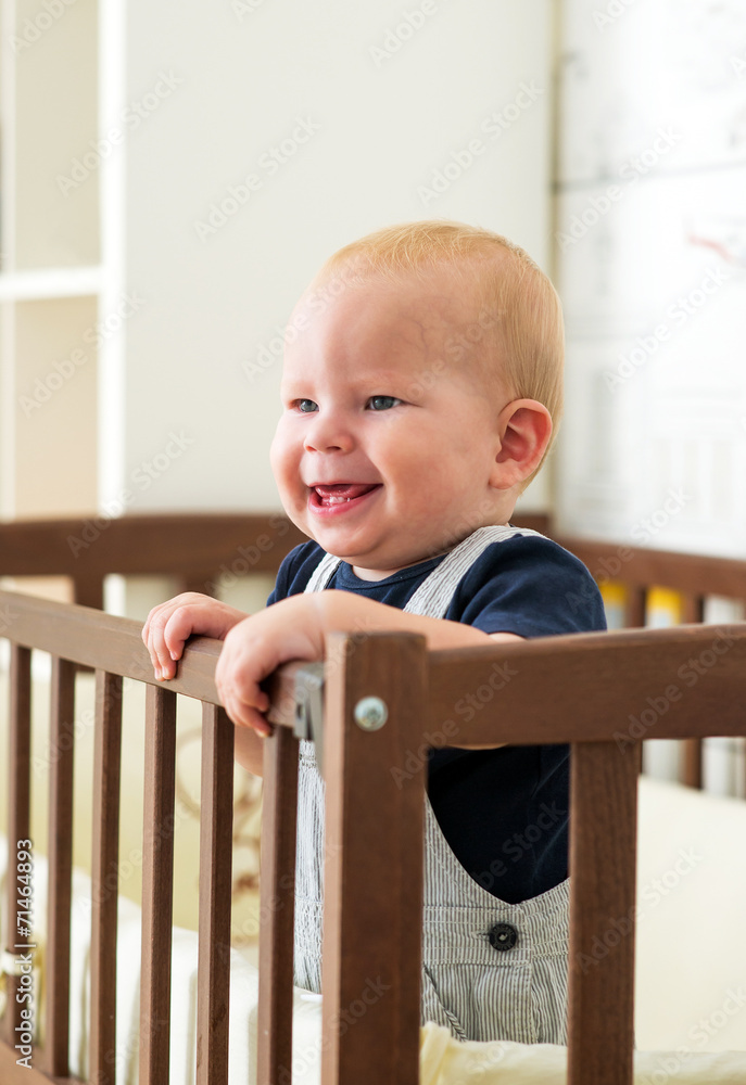 Baby boy is standing in the crib Baby boy is standing in the crib