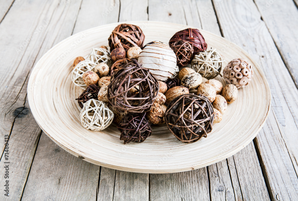 Decorative twig spheres lay in wooden bowl on wooden table Decorative twig spheres lay in wooden bowl on wooden table