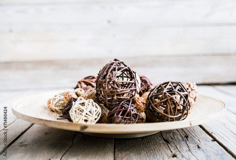 Decorative twig spheres lay in wooden bowl on wooden table Decorative twig spheres lay in wooden bowl on wooden table