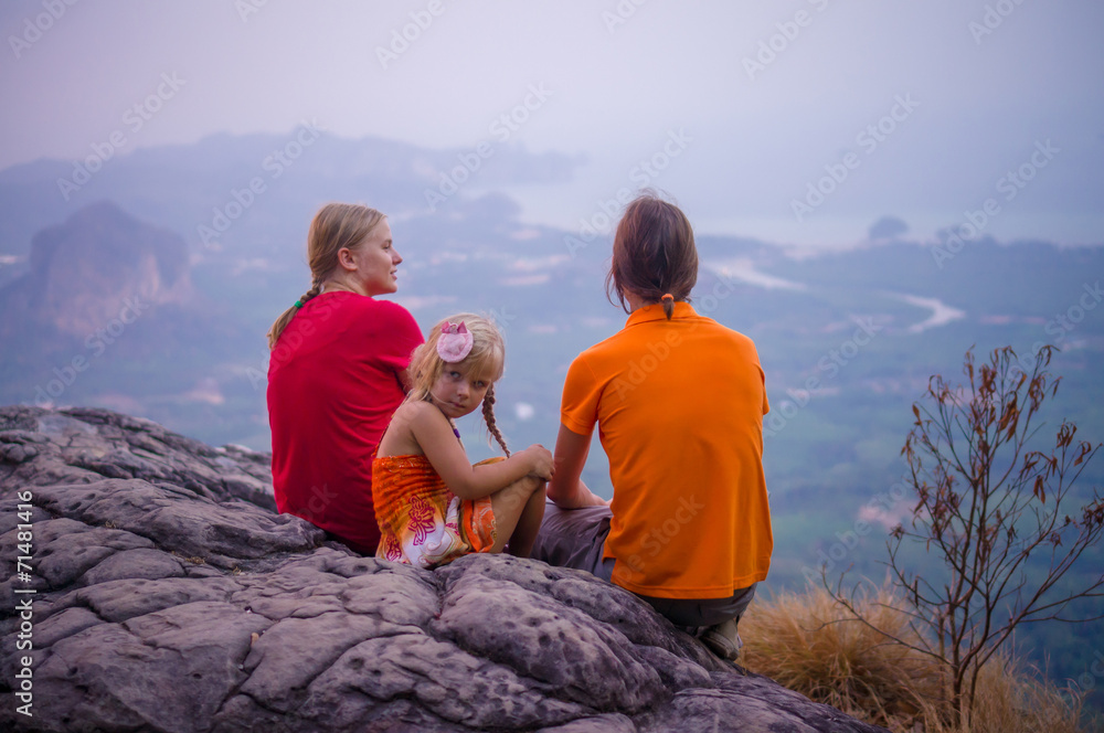 Family seat near cliff on the top of tropical island mountain on