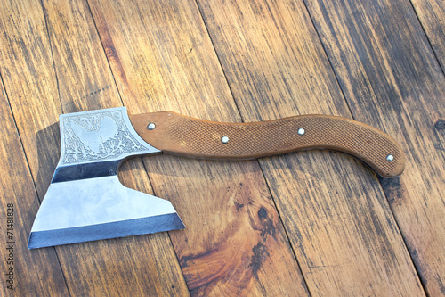 Old axe over wooden background