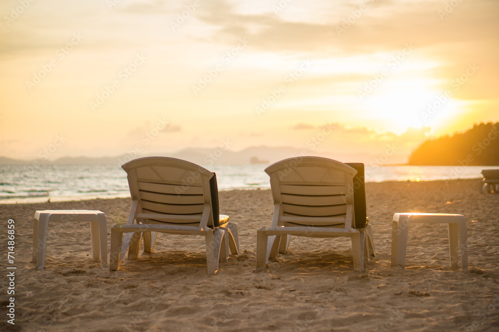 Two beach chairs at sunset near tropical ocean resort Two beach chairs at sunset near tropical ocean resort