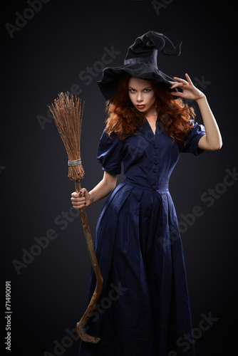 beautiful red-haired girl in a  costume witch Fototapeta