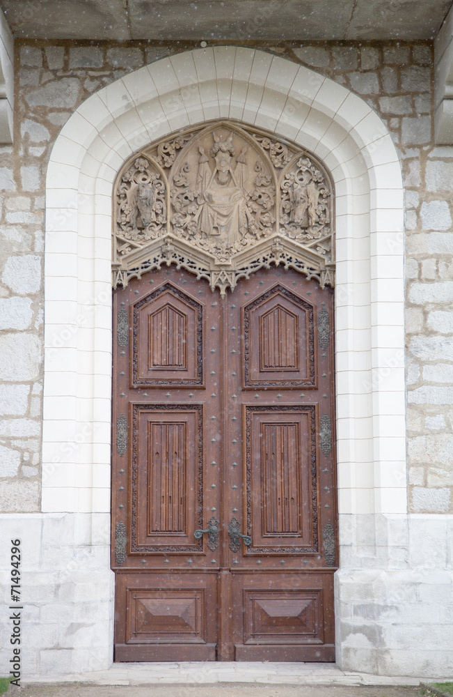 Old wooden door with ornaments in a knight's castle. with snowin Old wooden door with ornaments in a knight's castle. with snowin