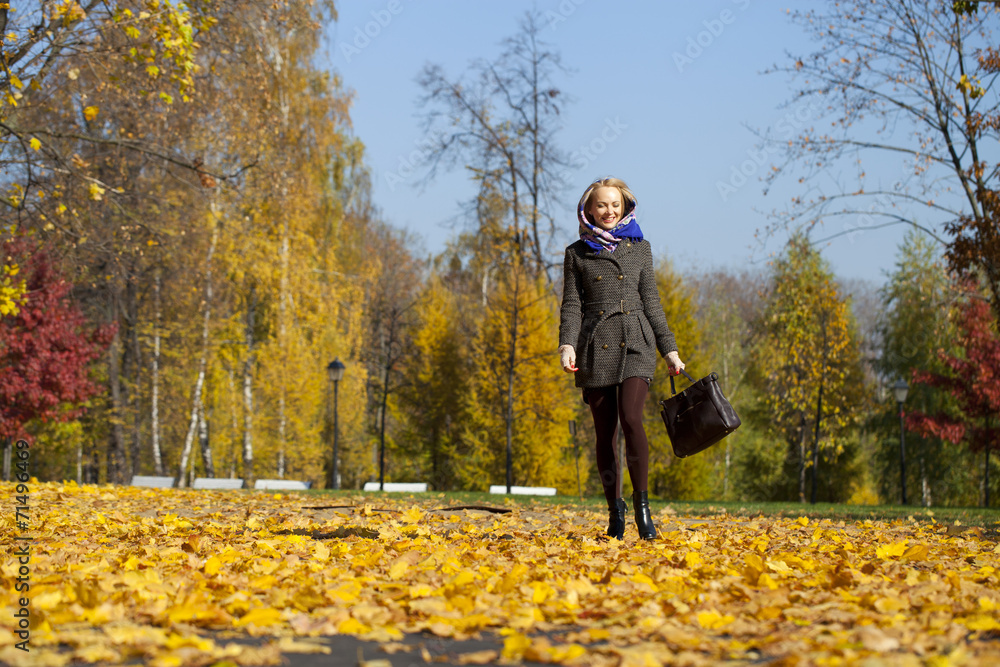 Young woman walking in autumn park