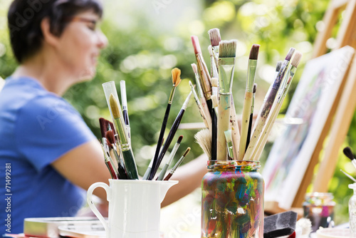Frau malt ein Bild im Garten
