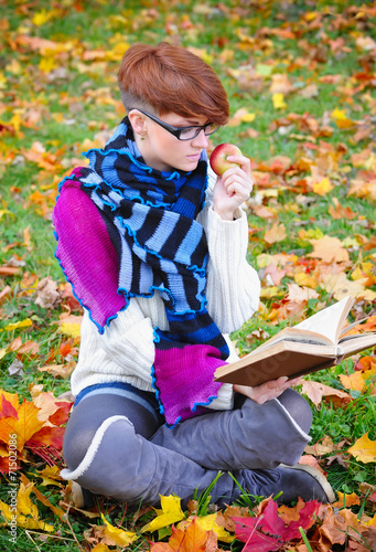 Beautiful girl with book in the autumn park