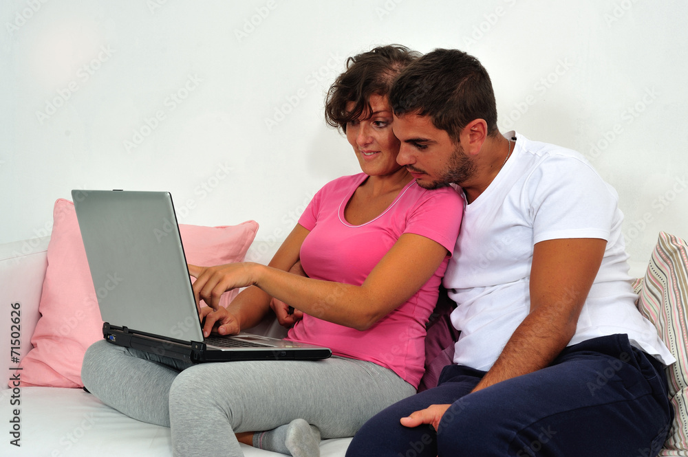 Couple sitting on sofa with laptop