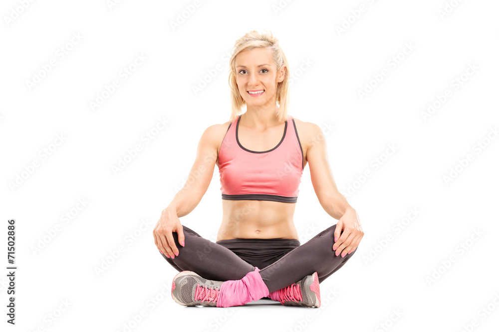 Young woman in sportswear sitting on the ground