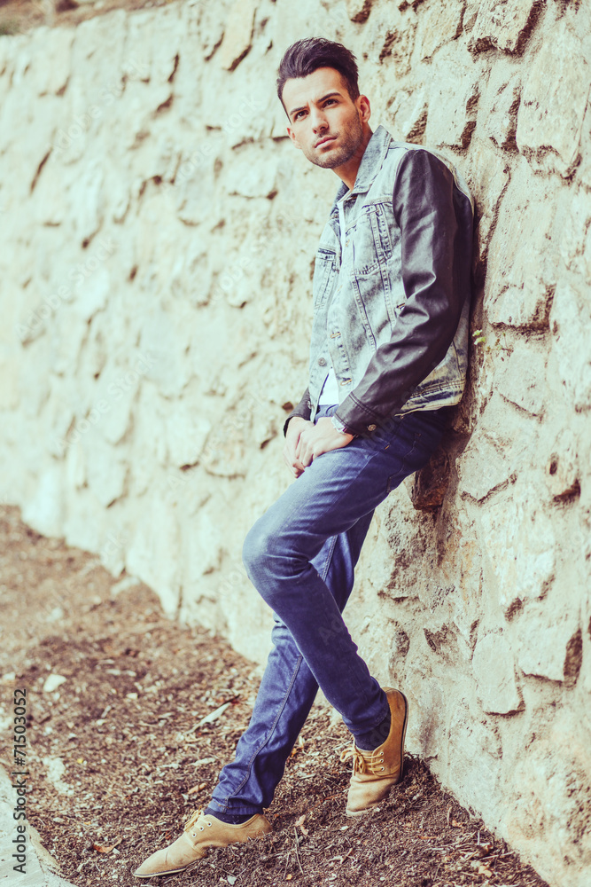 Attractive young handsome man, model of fashion in urban backgro Attractive young handsome man, model of fashion in urban backgro