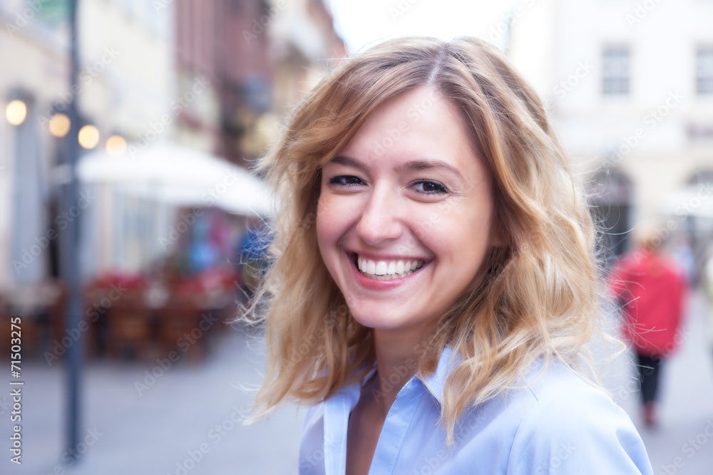 Frau mit blonden Locken in der Stadt hat Spass