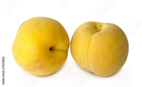 two yellow peaches on white background