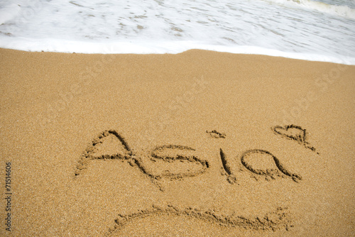 The word Asia written in sand on a beach