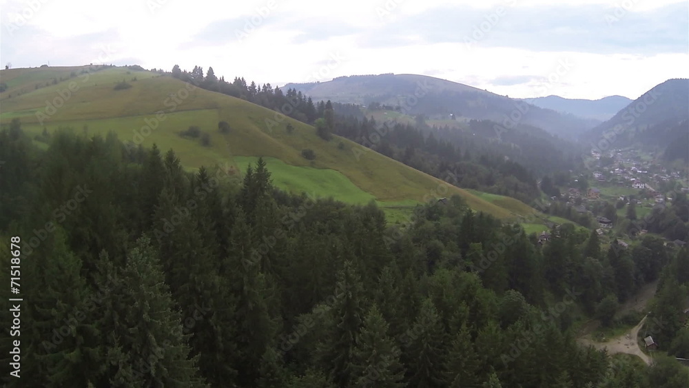 Hillsides with trees and village in cloudy day. Aerial Hillsides with trees and village in cloudy day. Aerial