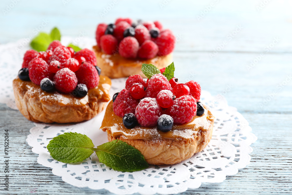 Sweet cakes with berries on table close-up