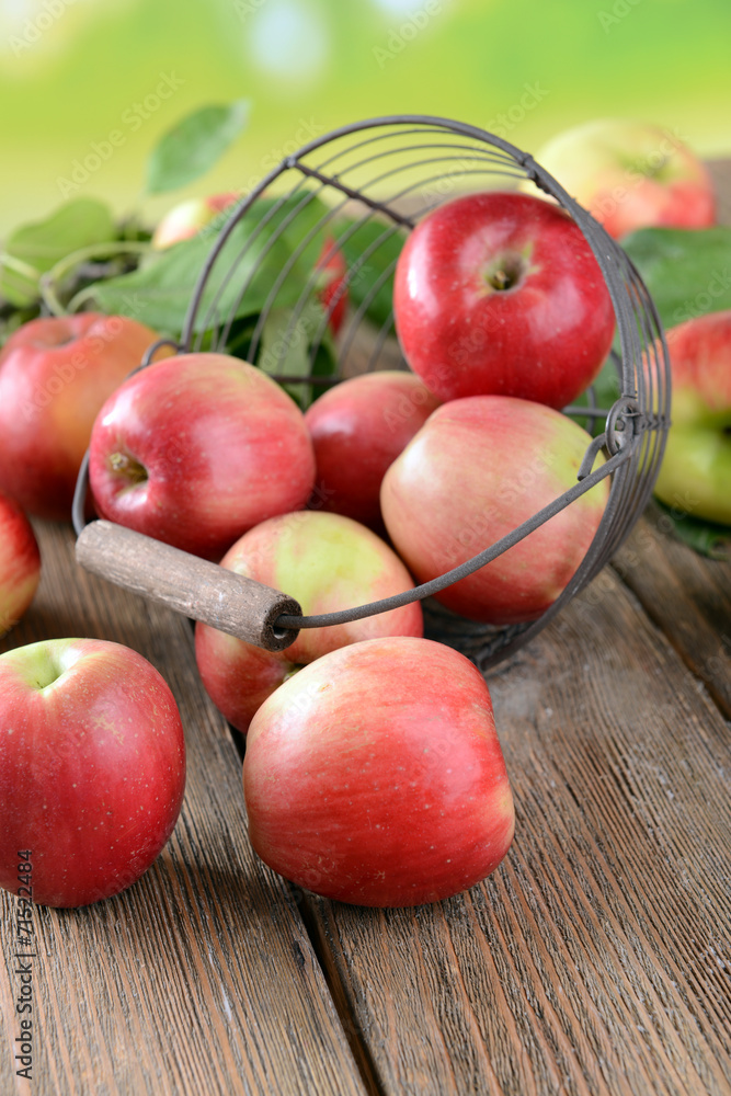 Sweet apples in wicker basket on table on bright background Sweet apples in wicker basket on table on bright background