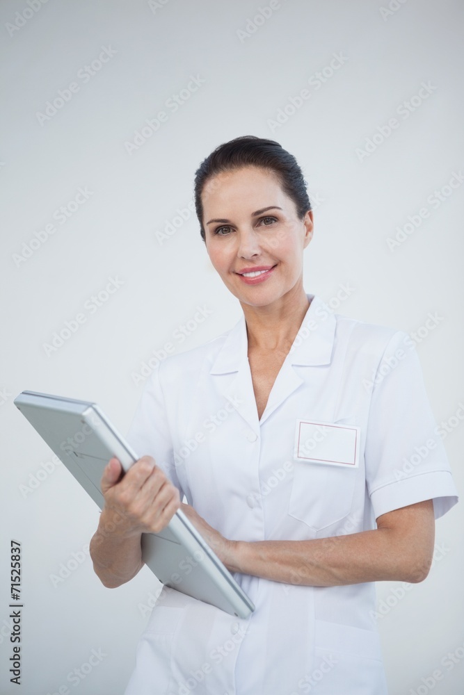 Smiling doctor holding a laptop Smiling doctor holding a laptop