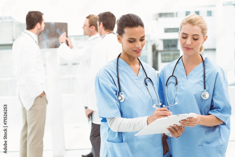 Two female surgeons looking at reports Two female surgeons looking at reports