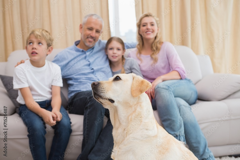 Parents and their children on sofa with puppy Parents and their children on sofa with puppy