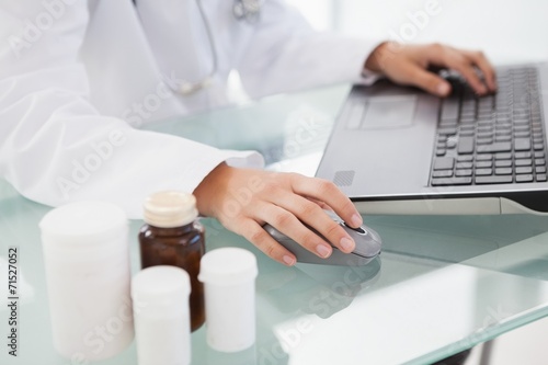 Doctor typing out prescriptions