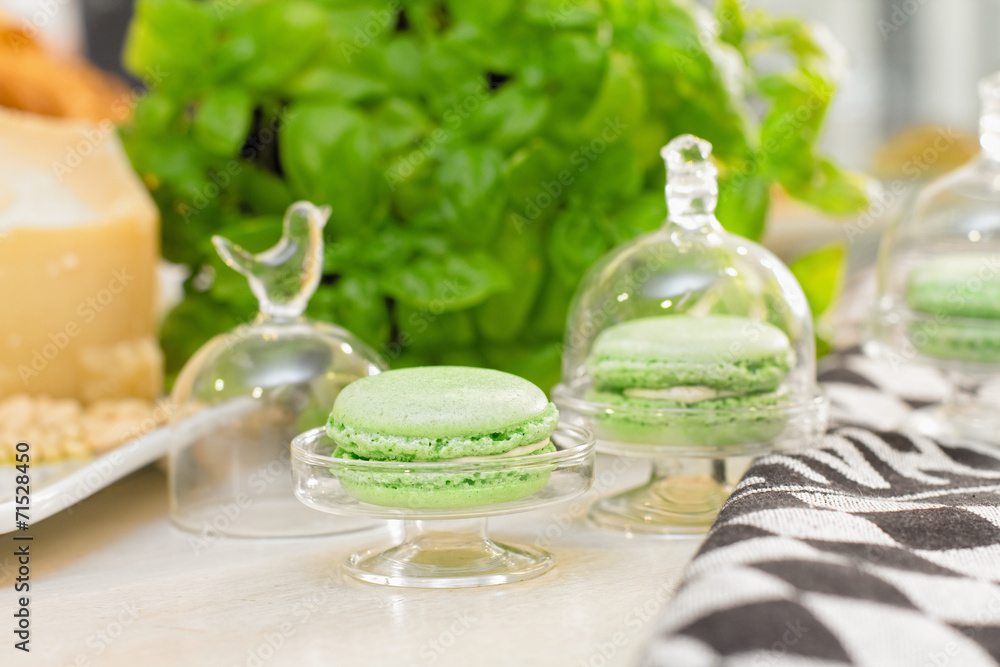 Pesto macaroons with pesto sauce ingredients in the background Pesto macaroons with pesto sauce ingredients in the background