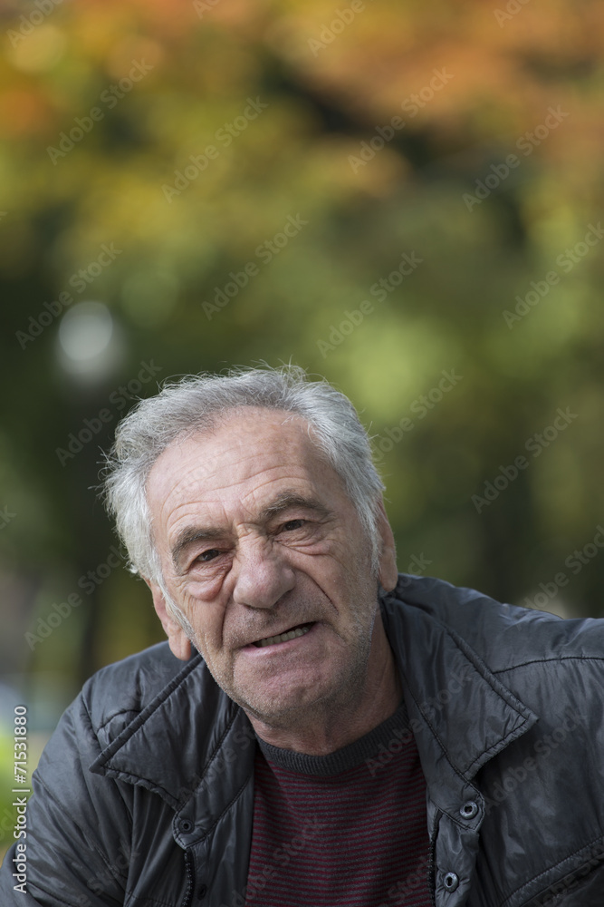 handsome old italian man in a park at fall