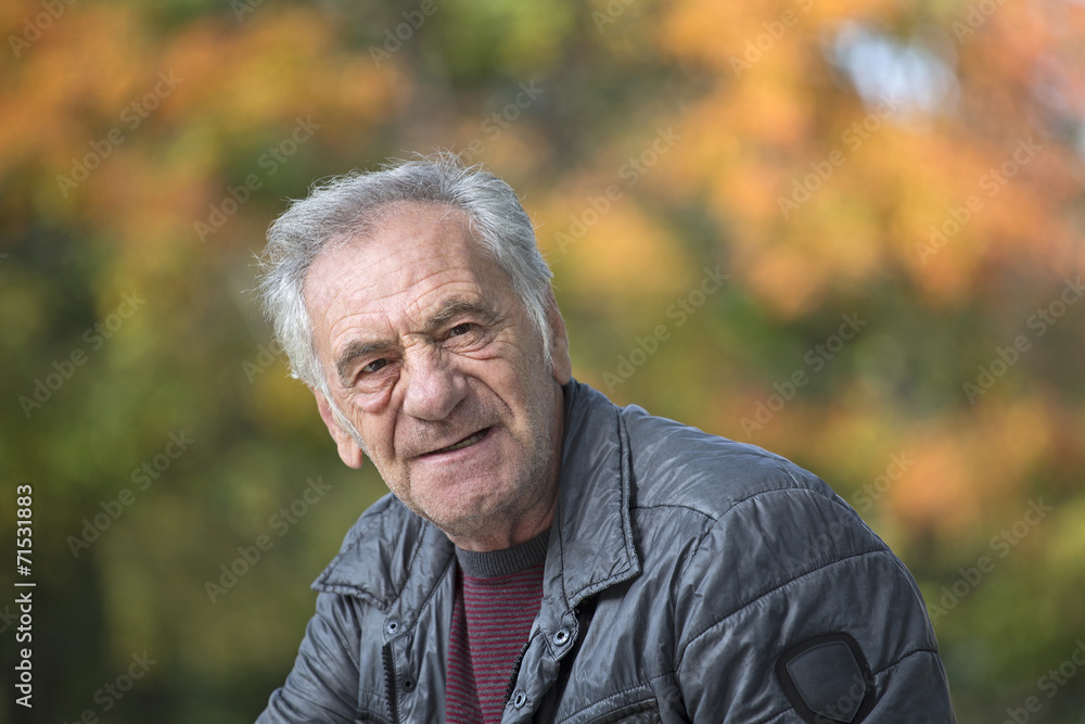 handsome old italian man in a park at fall handsome old italian man in a park at fall
