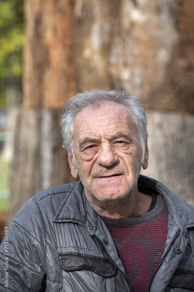handsome old italian man in a park at fall handsome old italian man in a park at fall
