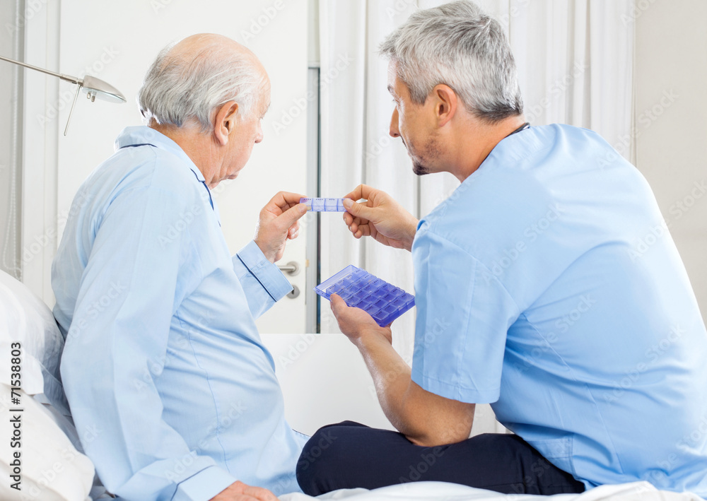 Fototapeta premium Caretaker Guiding Prescription To Senior Man