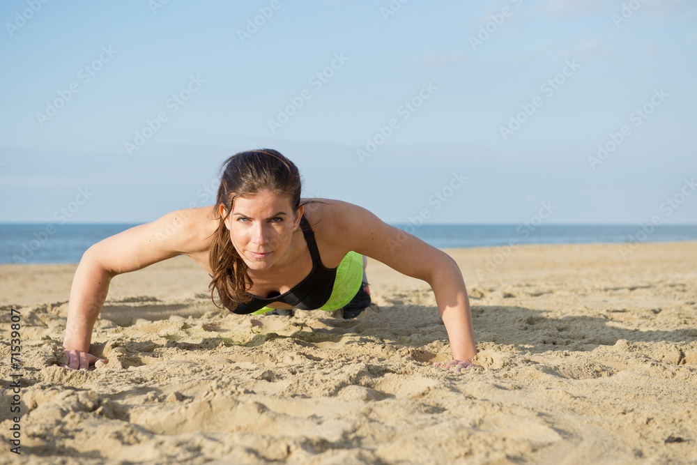 Woman pushing up on a beach Woman pushing up on a beach