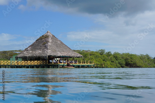 Caribbean restaurant over water with thatched roof