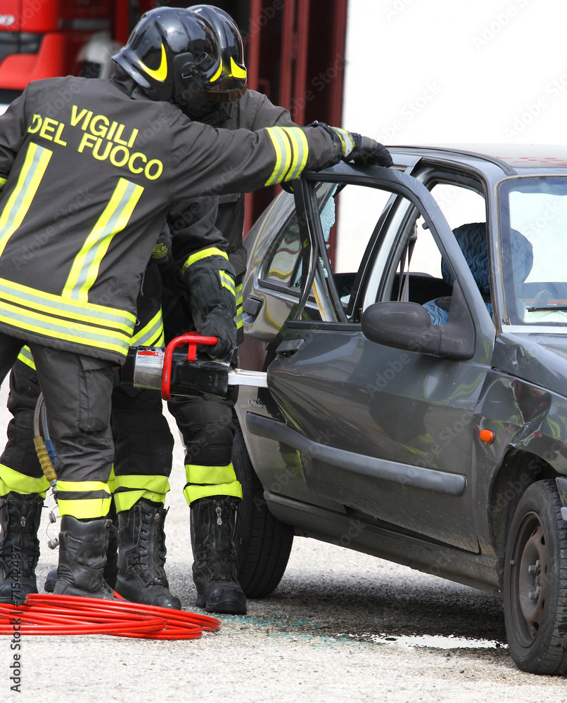 Firefighters open the door of the car with a powerful shears Firefighters open the door of the car with a powerful shears