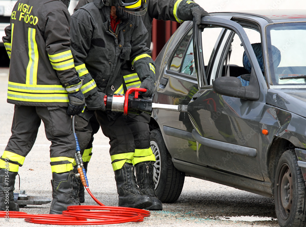 Firefighters open the door with a powerful pneumatic shears Firefighters open the door with a powerful pneumatic shears