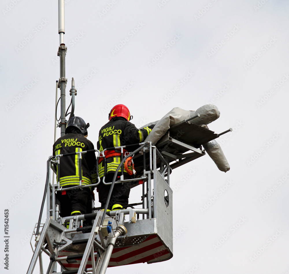 two firefighters during a rescue exercise a hurt with a dummy two firefighters during a rescue exercise a hurt with a dummy
