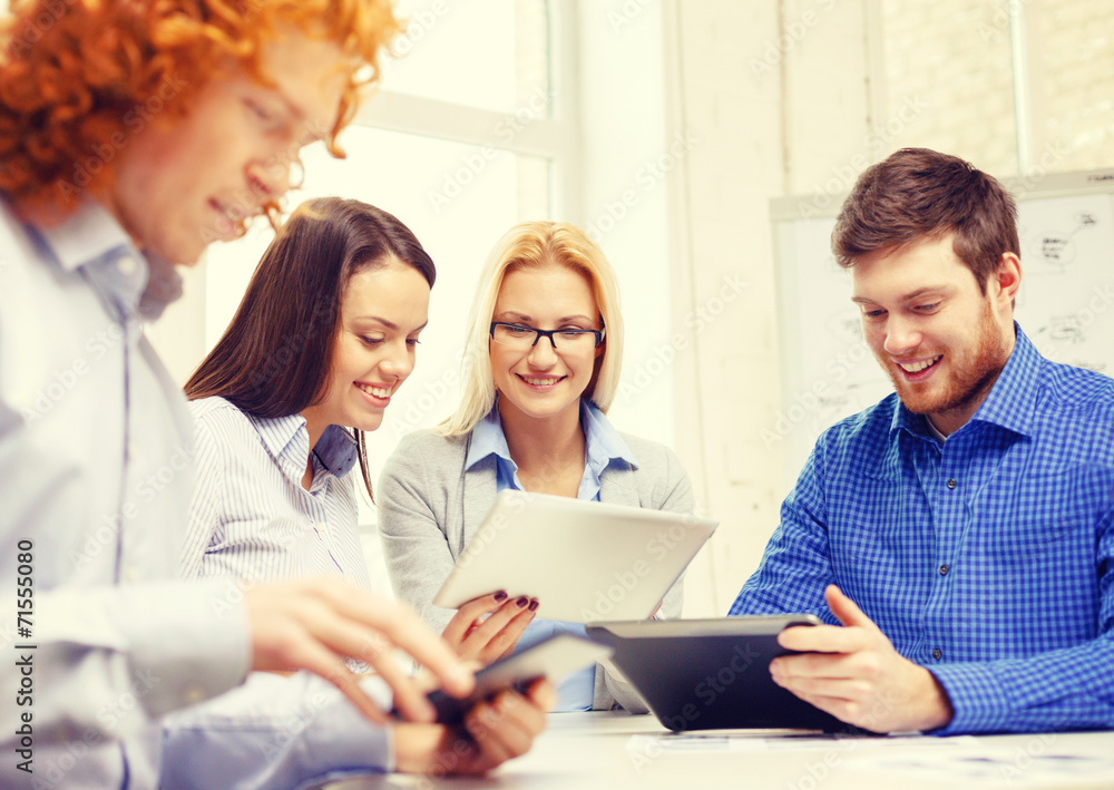 smiling team with table pc and papers working smiling team with table pc and papers working
