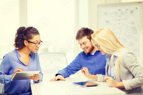 smiling team with table pc and papers working