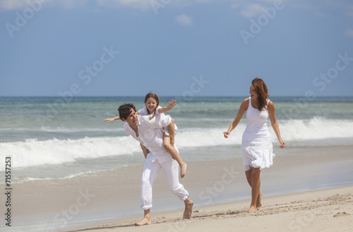 Mother, Father and Child Family Running Having Fun At Beach