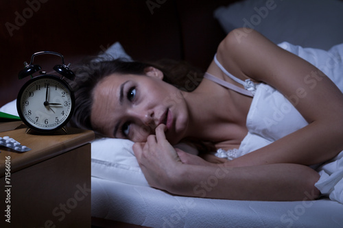 Woman lying in bed sleepless photo